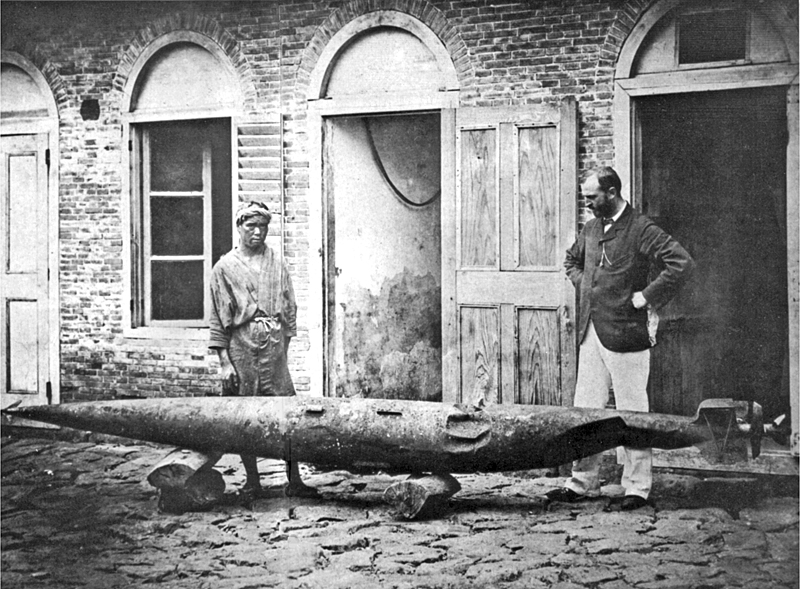 Robert Whitehead, és nagyobbik fia, John, egy sérült kísérleti torpedóval, a fiumei üzem udvarán, 1875 körül.