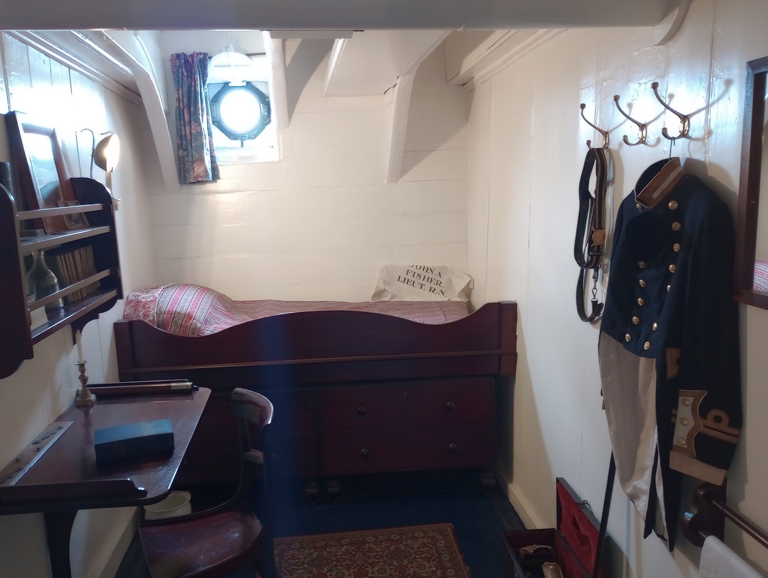 Az egyik tiszti kabin. A kabinok használati tárgyain feltüntetik a tulajdonos nevét, olyan tisztekét, akik valóban szolgáltak a Warrioron. Ez itt a későbbi Első Lord, John Arbuthnot Fisher kabinja, aki 1863-64 során a tüzérség hadnagyaként szolgált a Warrioron.