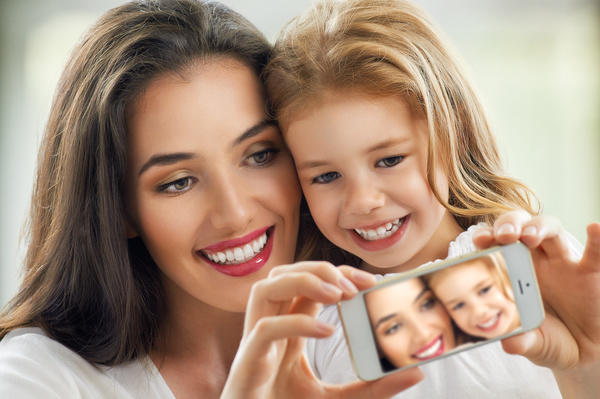 mother-and-daughter-use-a-smartphone-for-selfie-stock-photo.jpg