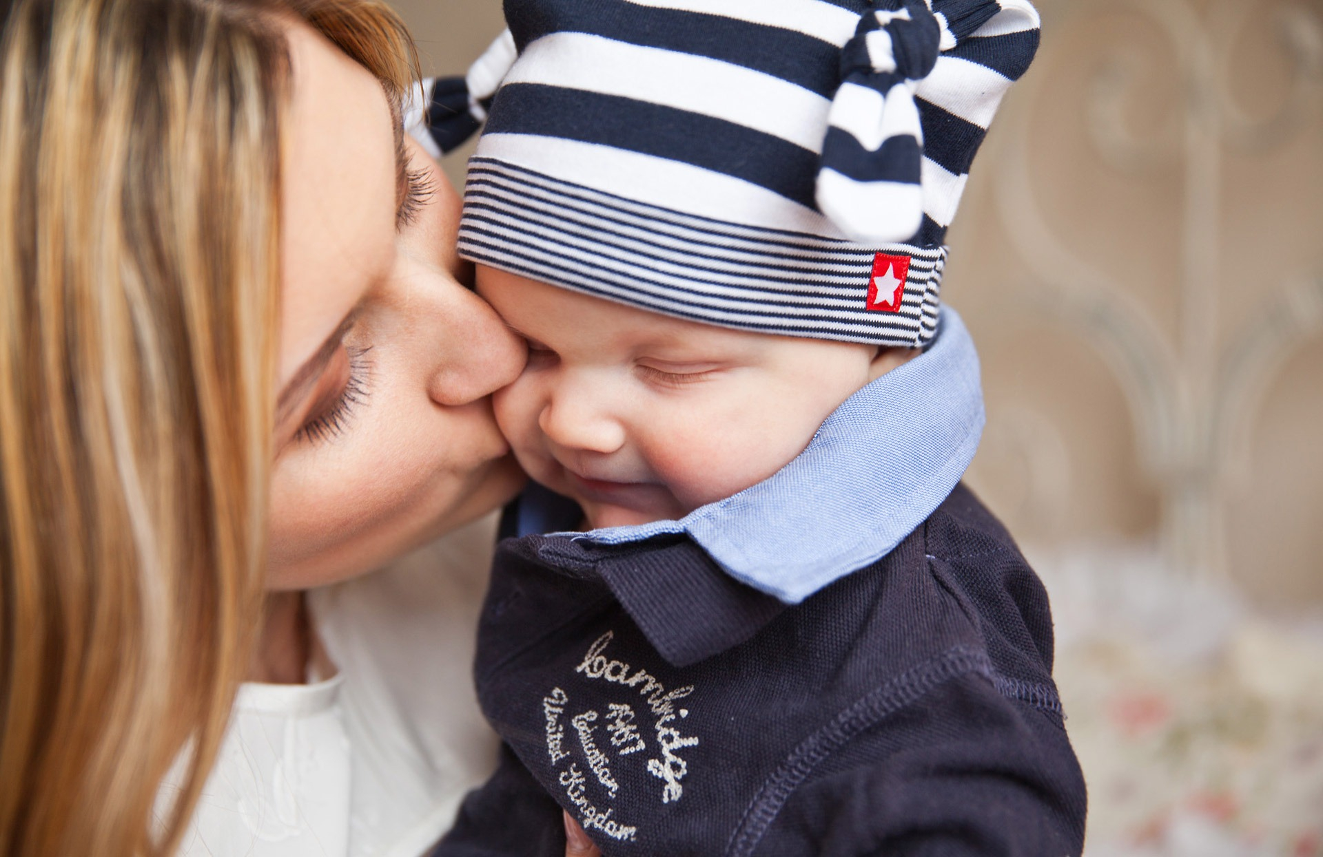 canva_woman_in_white_shirt_kissing_baby_with_black_and_white_stripe_knit_cap.jpg