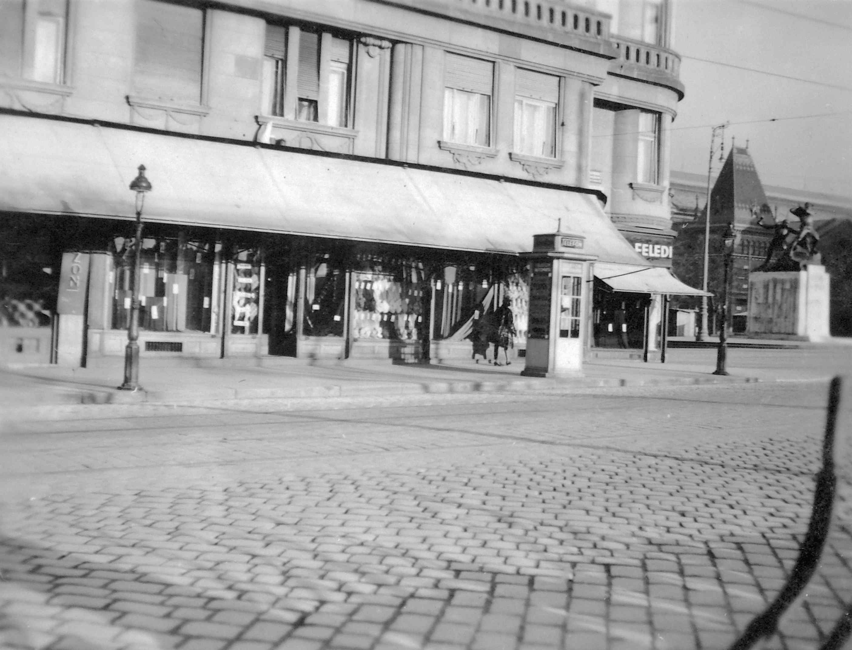A ház földszintjén a rakpart felőli oldalon is üzletek működtek.<br />A Belgrád (Ferenc József) rakpart - Fővám tér sarka 1935 körül, háttérben az 1. honvéd és népfölkelő gyalogezred emlékműve a Fővám téren.<br />Forrás: Fortepan #07582