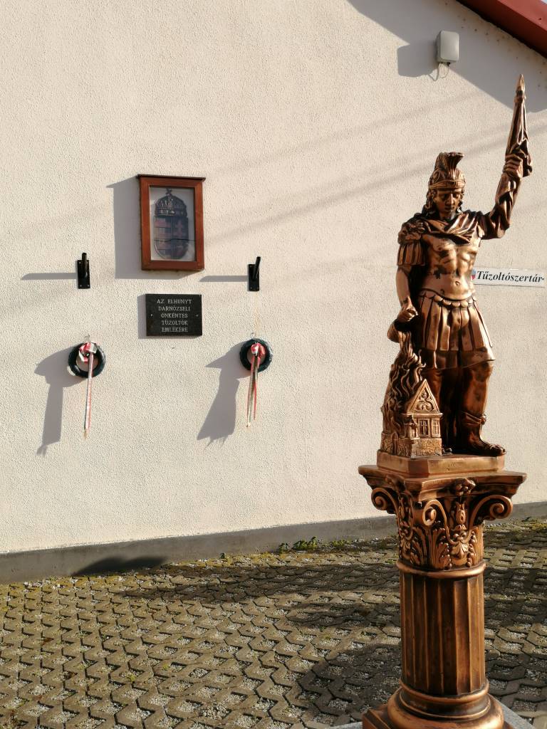 Szent Flórán-szobor és egy emléktábla a danózseli önkéntes tűzoltók szertára előtt - Darnózseli