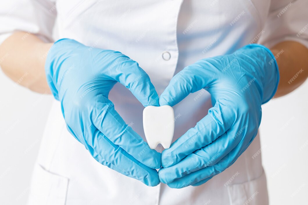 hands-dentist-doctor-blue-gloves-are-holding-tooth-model-form-heart_117638-761.jpg