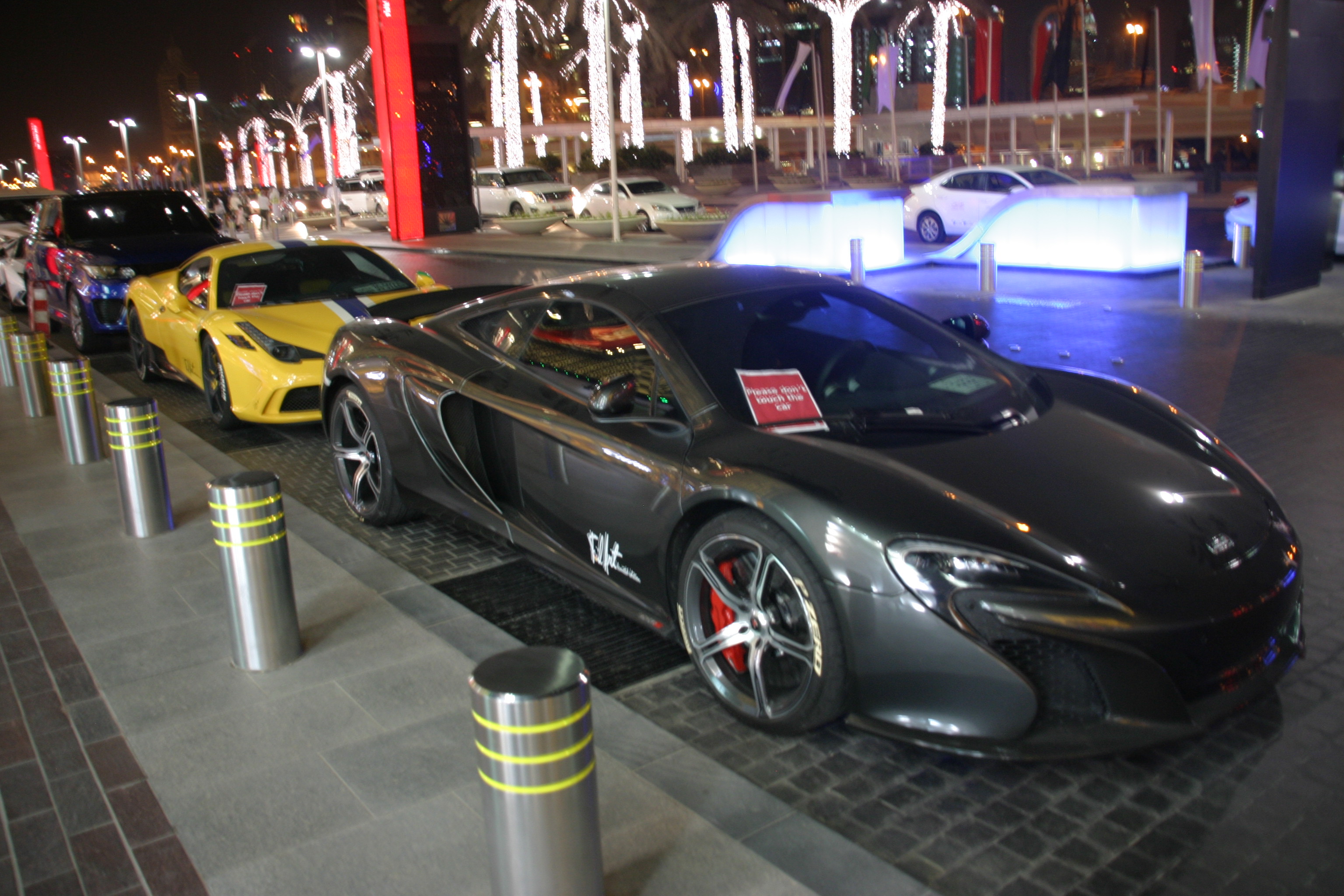 Luxus autók a Dubai Mall főbejárata előtt - a közbiztonságról sokat elmond, hogy a kocsikat nem zárják, hanem nyitva hagyják és sokszor az ablakba csak egy kis táblát tesznek ki, hogy ne tapogassák össze az idegenek a tisztára mosott autókat a kezeikkel