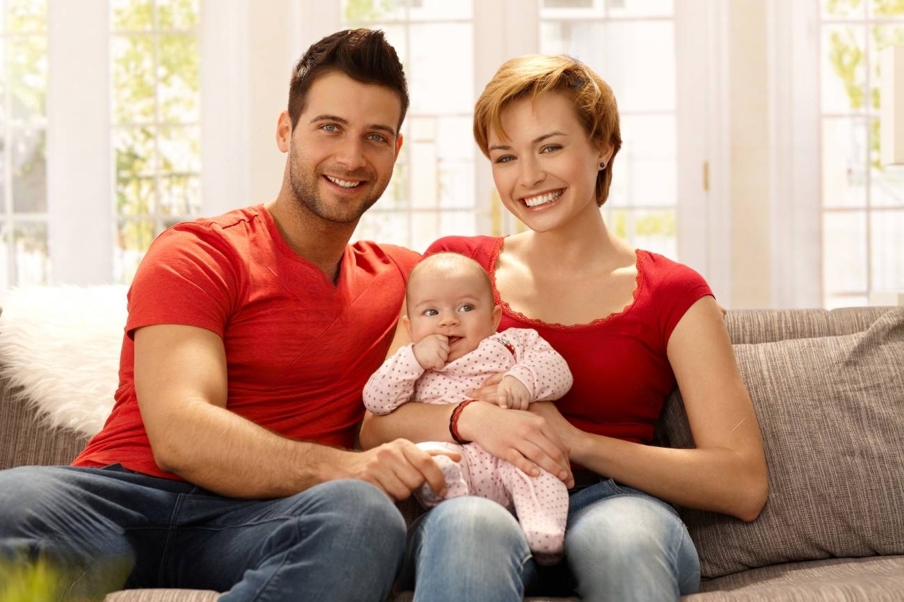 30170920-happy-young-married-couple-holding-baby-girl-on-lap-smiling-looking-at-camera-transformed.jpeg
