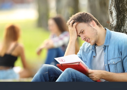 stock-photo-single-sad-student-checking-a-failed-exam-sitting-on-the-grass-in-a-park-with-unfocused-people-in-644598994-transformed.jpeg