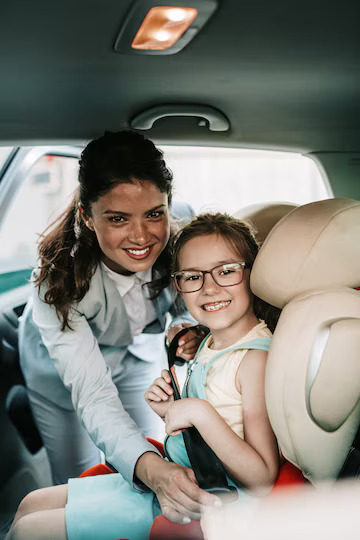 young-businesswoman-helping-her-daughter-fasten-seatbelts-car-while-girl-is-sitting-safety-child-car-seat_473712-2245.jpg