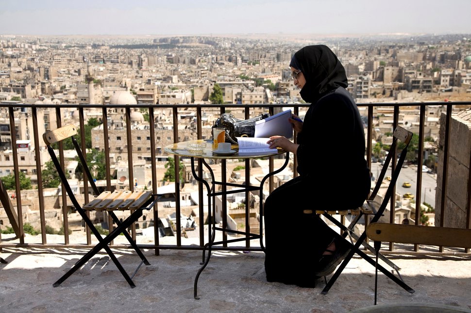 a_woman_sits_at_a_table_in_an_aleppo_bar_on_may_21_2009.jpeg