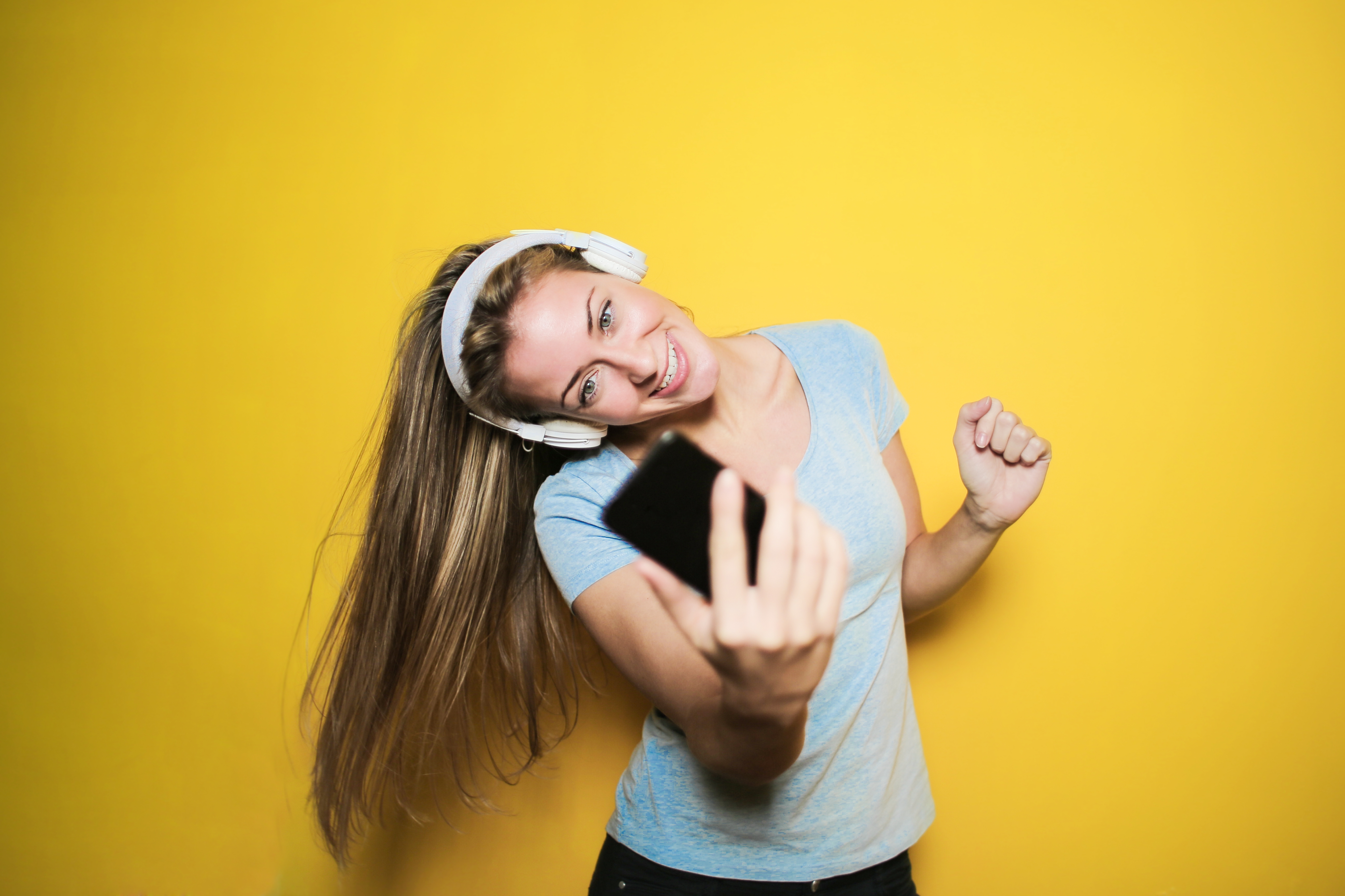 satisfied-woman-taking-selfie-on-smartphone-in-studio-3783517.jpg