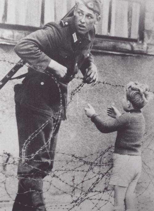 kelet német katona segít egy fiúnak 1961.jpg