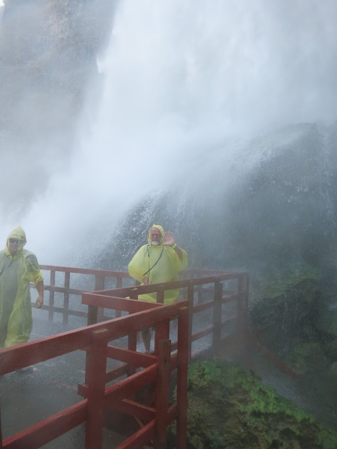 Még volt egy attrakció a Passban, a Hurricane. Ez is liftezéssel kezdődött, itt sárga köpenyt kaptunk, és lent, a platón megtapasztalhattuk a hurrikán szélerősségét, és azt, milyen az, amikor nem a vízben vagy, de minden tele van vízzel. Itt szandált is adtak mindenkire, de száraz gatyát is kellett volna, ebben a szélben az esőkabát semmit nem ért, én derékig áztam el. Gabi nem jött fel odáig, mint én, így született ez fénykép is. Minden szempontból lélegzetelállító volt az élmény, itt  a platón szó szerint, de a vízesést nézve akár fentről, akár lentről, eszmei értelemben is. 