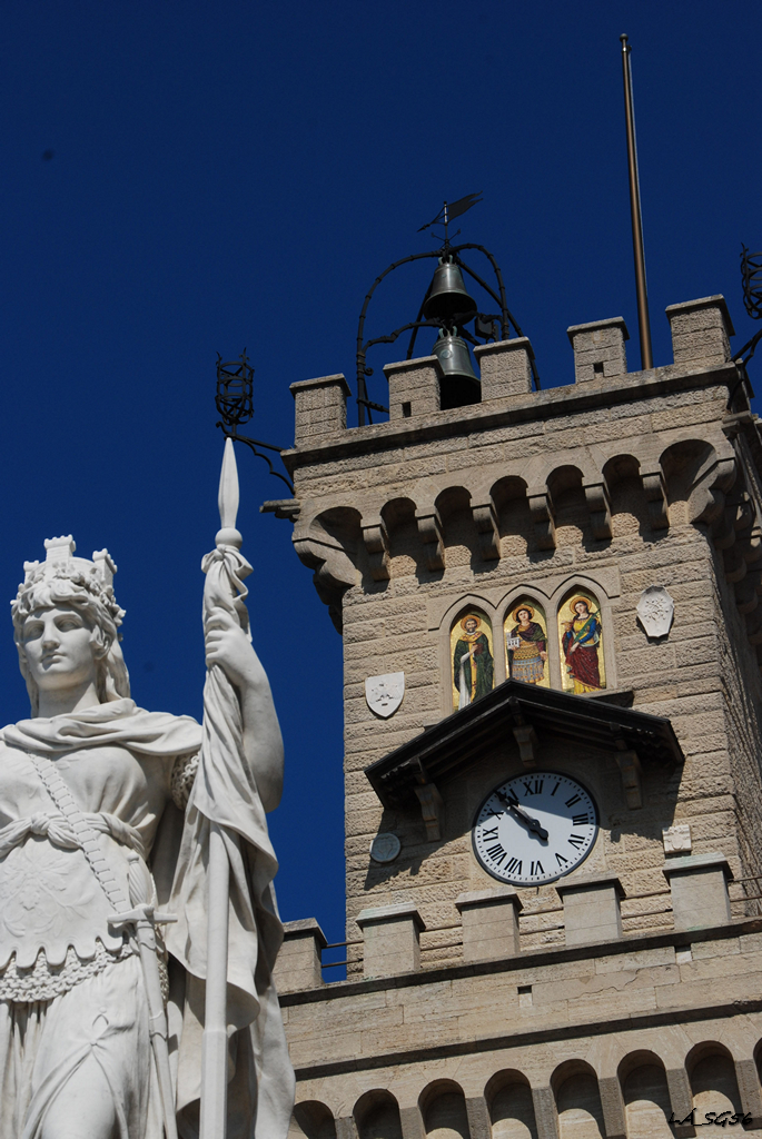 A Parlament tornya, rajta a védőszentekkel, előtte a Szabadság szobra (Libertas, ami egyben San Marino mottója, minden állami vagy államhoz kötődő intézményen megtalálható, de a hotel előcsarnokában a padlóba mozaikolva is).