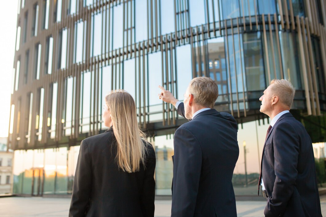 group-business-partners-formal-suits-pointing-office-building-meeting-outdoors-discussing-real-property-back-view-commercial-real-estate-concept_74855-7313.jpg