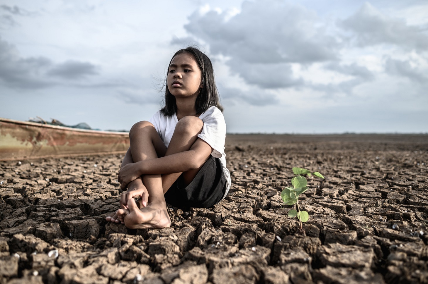 girls-sitting-hugging-their-knees-looking-sky-having-trees-dry-ground_jcomp_freepik.jpg