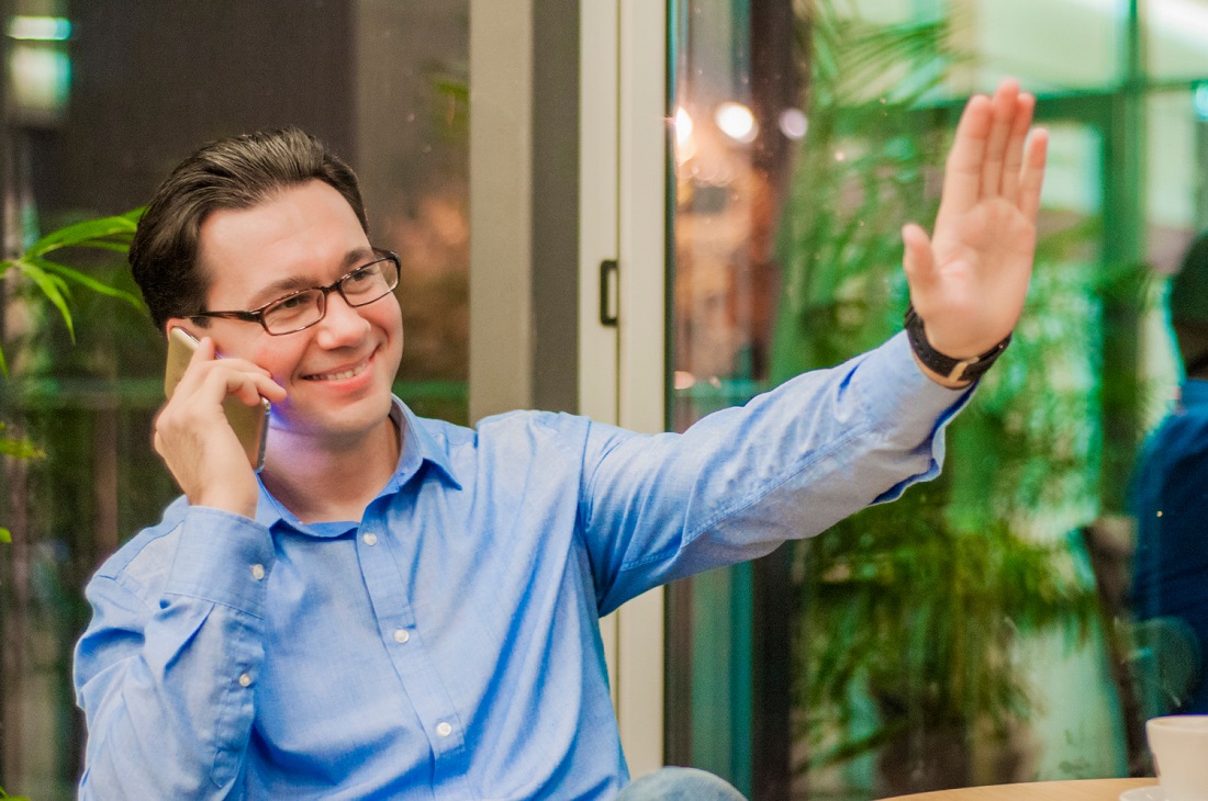 smiling-young-man-talking-phone-showing-greeting-gesture_dragana_gordic_freepik.jpg