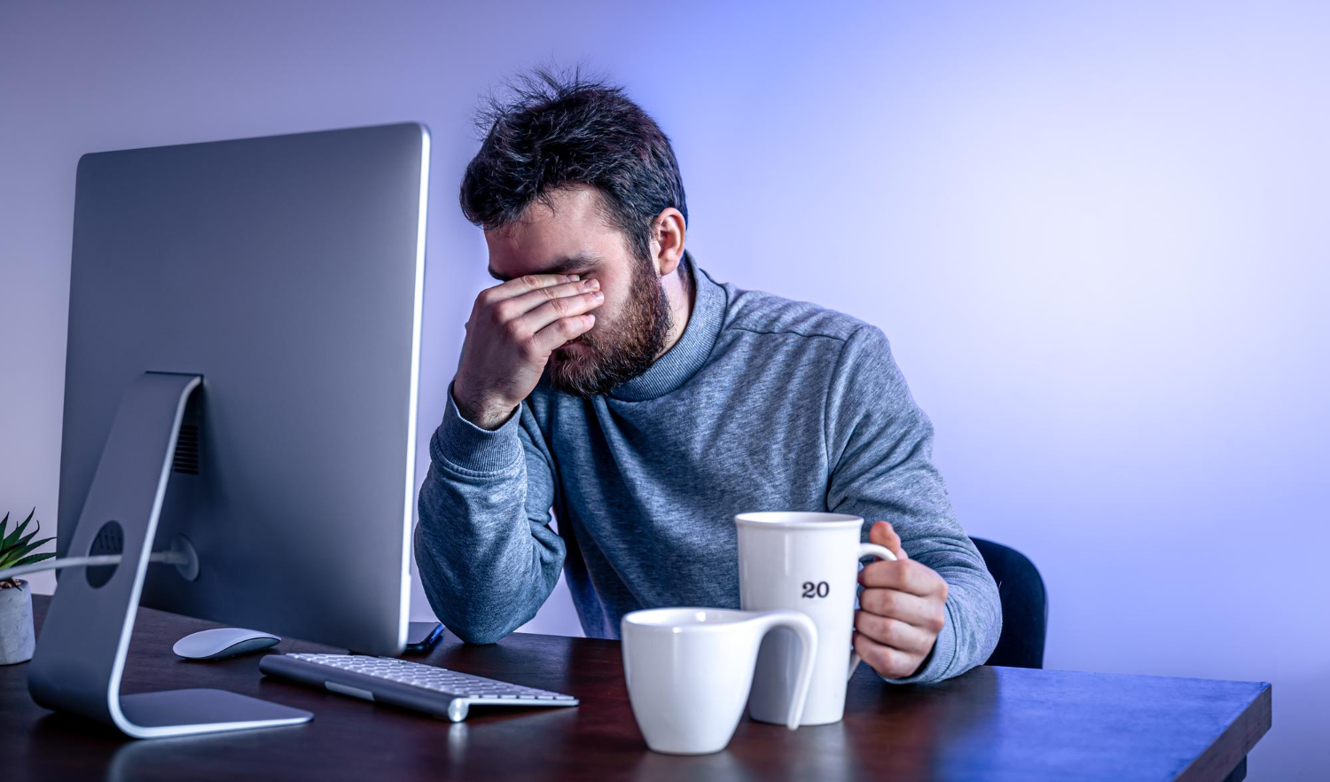 tired-man-sits-front-computer-with-cup-coffee-colored-lighting_pvproductions_freepik.jpg