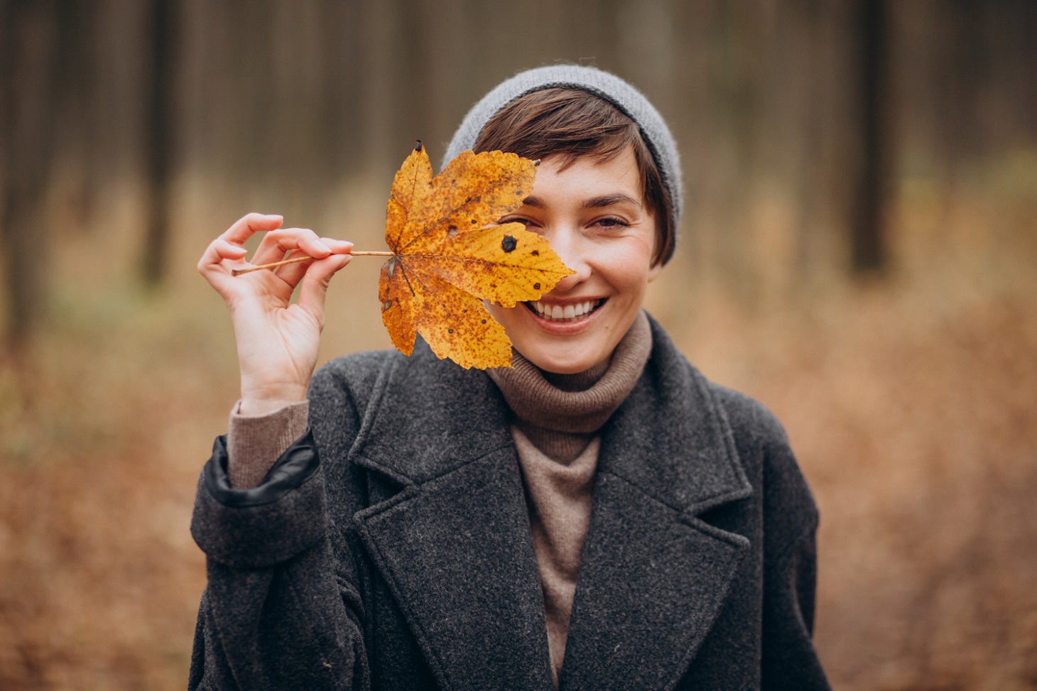 young-woman-autumn-park-holding-leaf-by-face_senivpetro_freepik.jpg