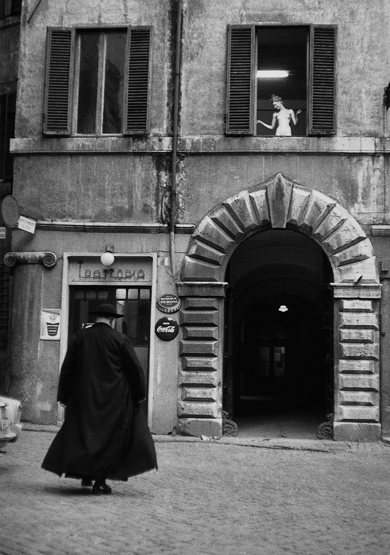 Fotó: Sabine Weiss<br />Prêtre devant une trattoria, Rome [Priest before a trattoria, Roma]<br />Italie, 1957<br />Silver gelatin print<br />© Sabine Weiss