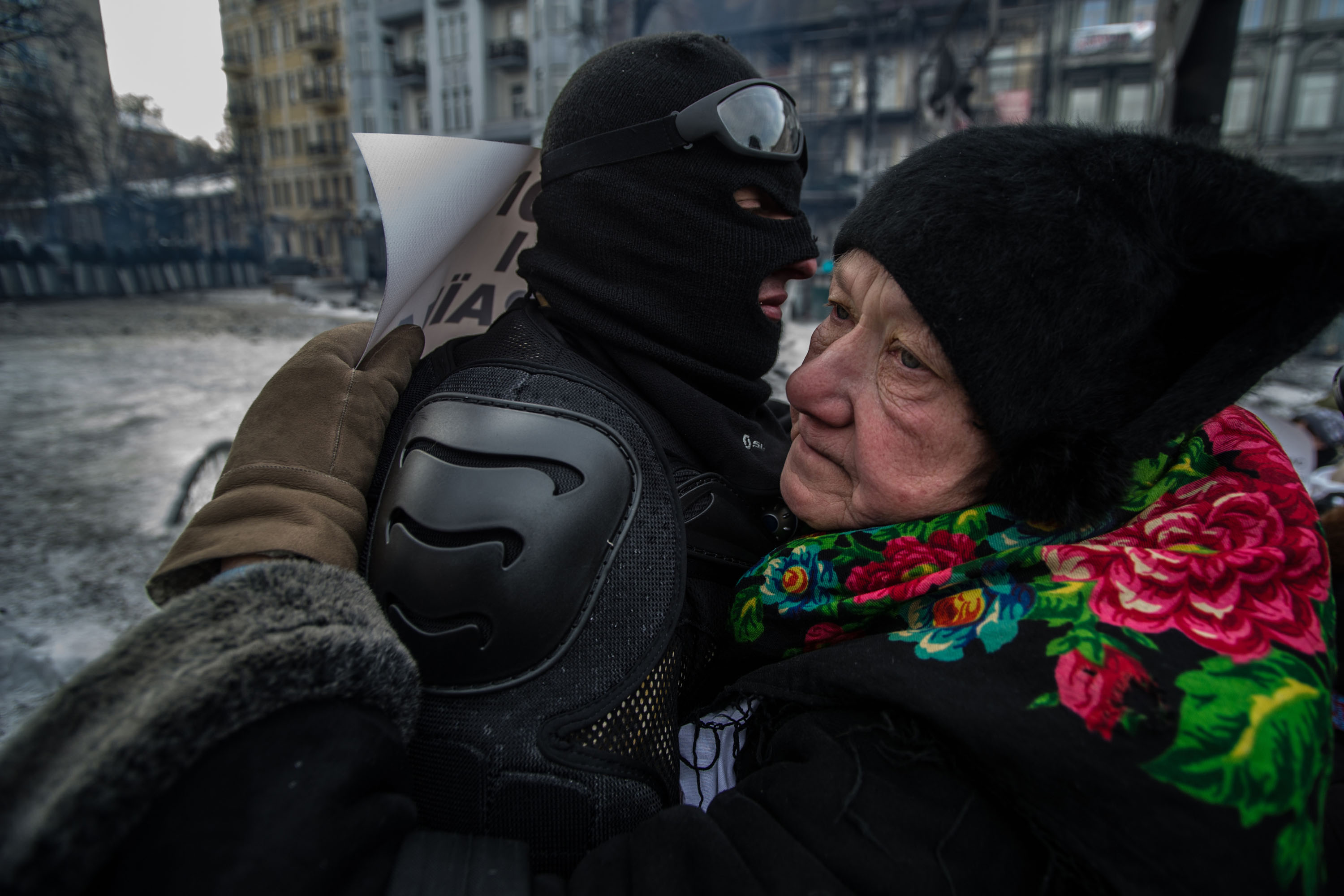 Egy idős hölgy megölel egy maszkos tüntetőt a Hrusevszkohó úti barikádon, Kijevben 2014. január 29-én..jpg