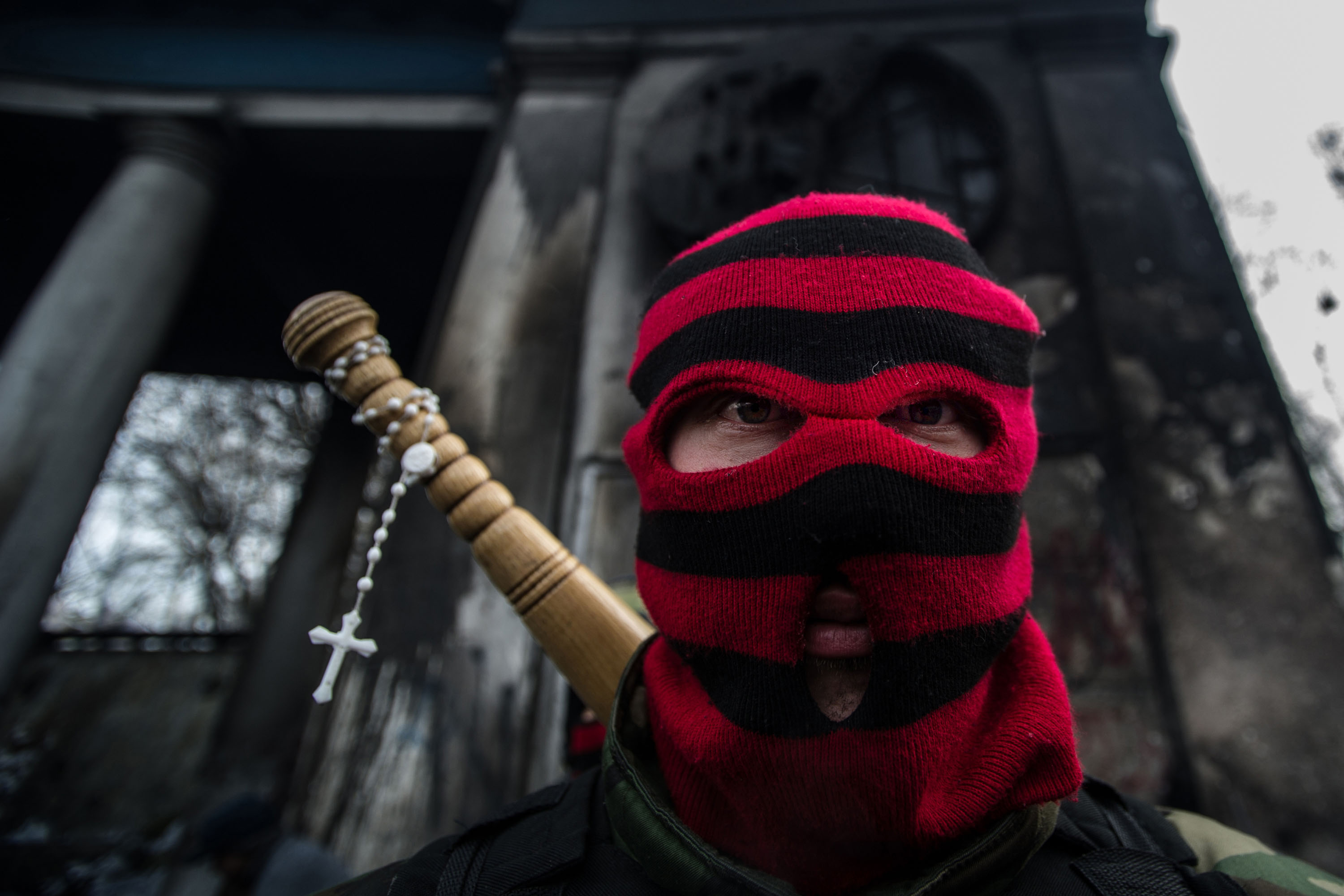 Egy maszkos tüntető áll a Hrusevszkohó utcában felállított barikádon, Kijevben 2014. febuár 2-án..jpg