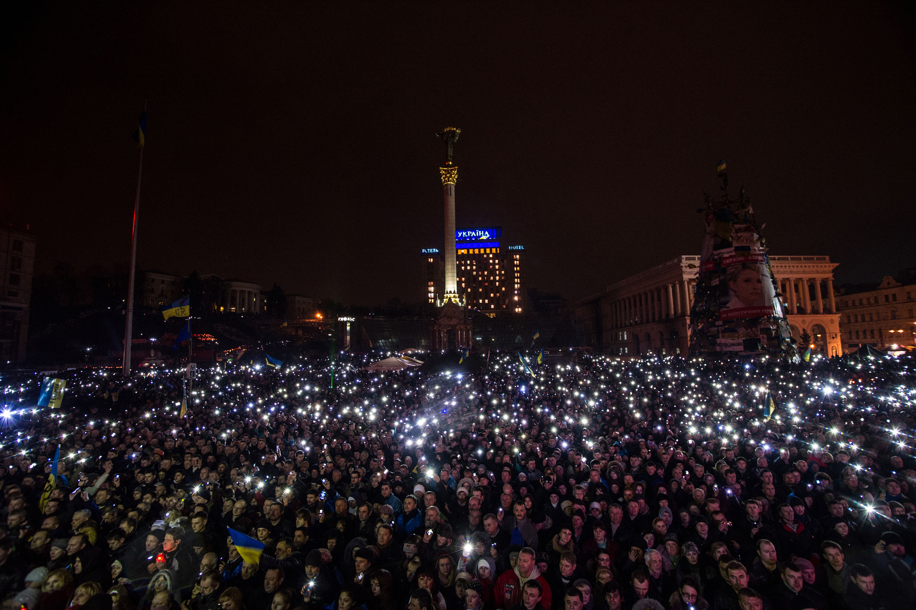 Résztvevők mobiltelefonjaikkal világítanak a csütörtöki összecsapások áldozatainak emlékére rendezett gyászszertatráson a kijevi Függetlenség terén, a Majdanon 2014. február 22-én..jpg