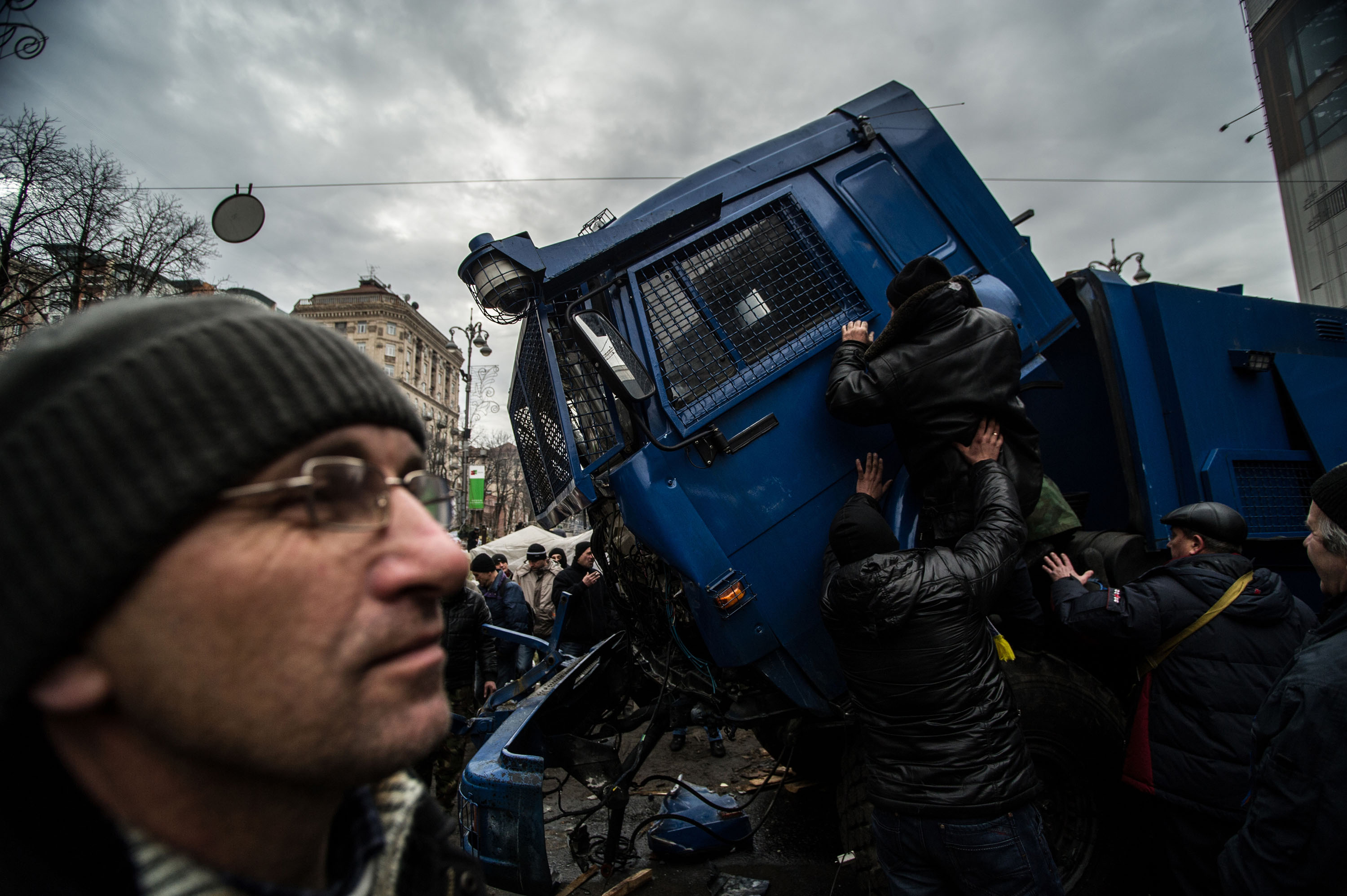 Tüntetők ártalmatlanítanak egy vízágyút a Krescsatjuk úton, Kijevben 2014. február 23-án..jpg