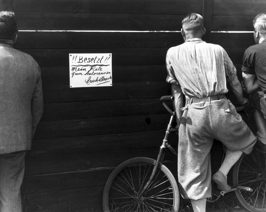 Fotó: Glass Zoltán: Nem fizető nézők leskelődnek a kerítésen át, 1932 © Zoltan Glass/National Media Museum/SSPL