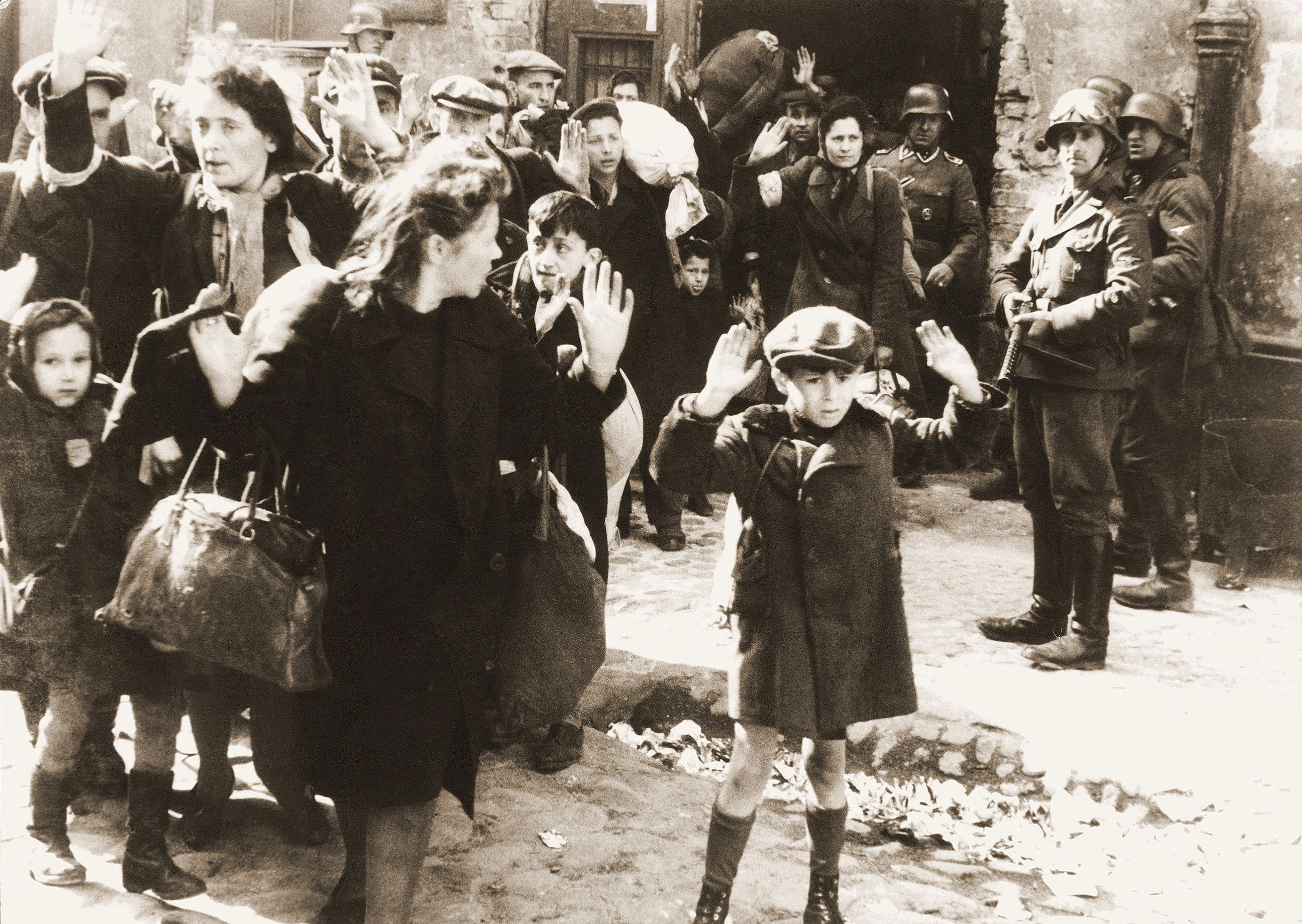 A náci holokauszt egyik legbeszédesebb fotóját 1943 áprilisában készítette a varsói gettófelkelés leverésekor egy SS-katona.<br /><br />A támadást vezető Stroop „Varsóban nincs többé zsidónegyed” címmel 75 oldalas jelentést állított össze a gettó felszámolásáról, melyet 52 fotóval illusztrált. Ezek egyike a felemelt kezű kisfiút ábrázoló kép is. Hogy a fotó pontosan kit ábrázol, arról megoszlanak a vélemények. Az igazság a fiú nevéről talán már soha nem derül ki, de a holokauszt egyik németek által dokumentált, leghíresebb fotójának drámai hatása és üzenete örökké megmarad.