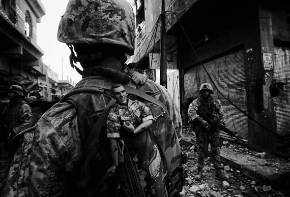 Fotó: Anja Niedringhaus: A US Marine of the 1st Division carries a GI Joe mascot as a good luck charm in his backpack while his unit pushes further into the western part of the city,<br />Fallujah, Iraq, November 2004<br />© picture alliance / AP Images