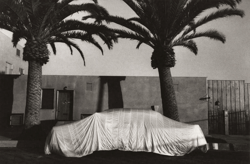 Robert Frank (American, born Switzerland, 1924)<br />Americans 34<br />Covered Car – Long Beach, California<br />1956<br />Gelatin silver print<br />Image: 21.4 x 32.7 cm (8 7/16 x 12 7/8 in.)<br />Lent by The Metropolitan Museum of Art, Gilman Collection, Purchase, Ann Tenenbaum and Thomas H. Lee Gift, 2005<br />Photograph © Robert Frank, from The Americans