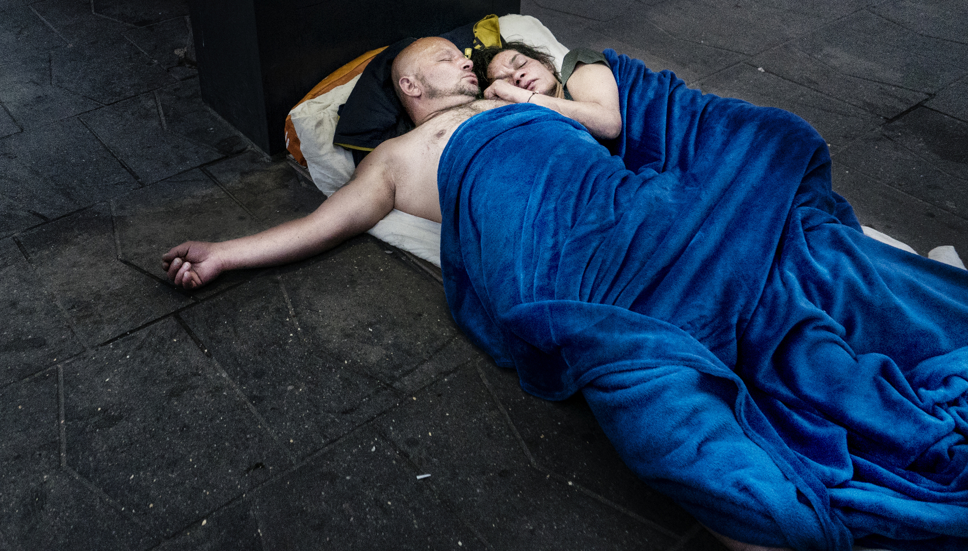 Társadalomábrázolás, dokumentarista fotográfia (egyedi)<br />1. díj: Giampiero Assumma (szabadfoglalkozású): Hajléktalanként élni Budapesten<br /><br />Fotó: Hajléktalan pár a Kálvin téren.