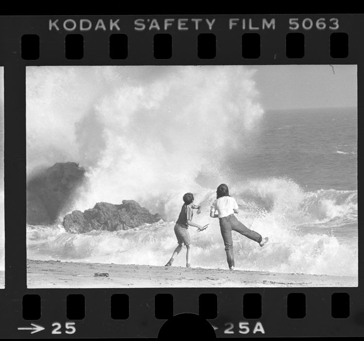Fotó: Két fiatal nézi, ahogy a hullámok megtörnek a sziklákon, Point Mugu State Park, Calif., 1979 © UCLA Library/Los Angeles Times