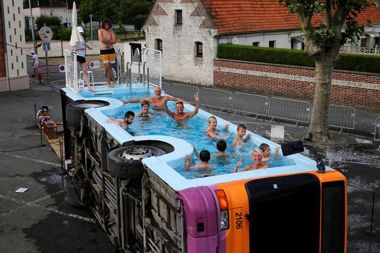 Fotó: Pascal Rossignol: Az emberek a „le bus piscine” elnevezésű, leselejtezett városi autóbuszban fürödnek, amely a francia művész, Benedetto Bufalino alkotása, Gosnay, Franciaország, Bethune közelében, 2019. július 10. © Reuters/Pascal Rossignol