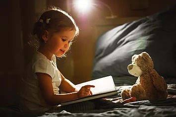 child-girl-reading-a-book-in-bed-before-going-to-sleep-picture_csp42395616.jpg