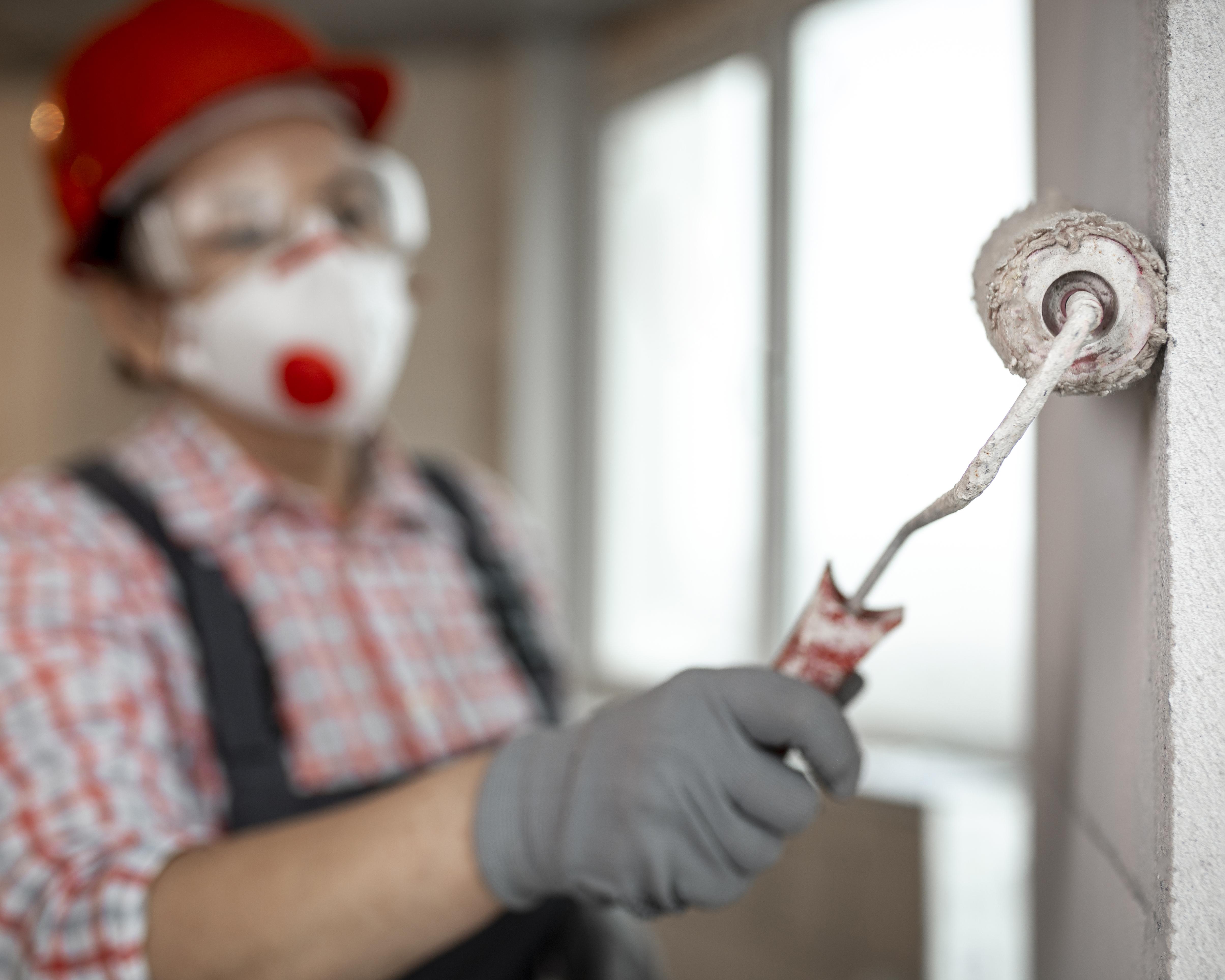 female-construction-worker-with-helmet-paint-roller.jpg