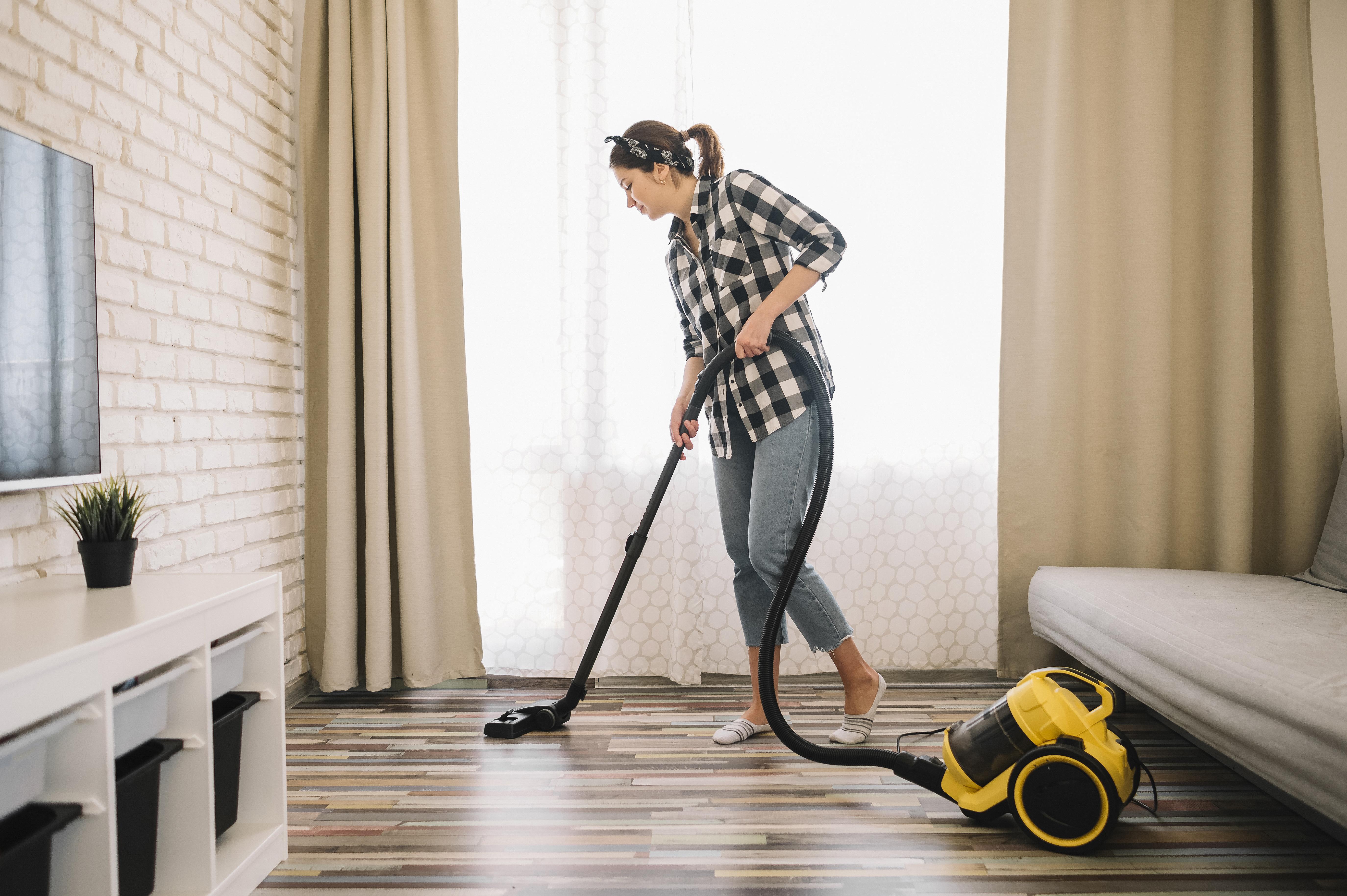 full-shot-woman-vacuuming-living-room.jpg
