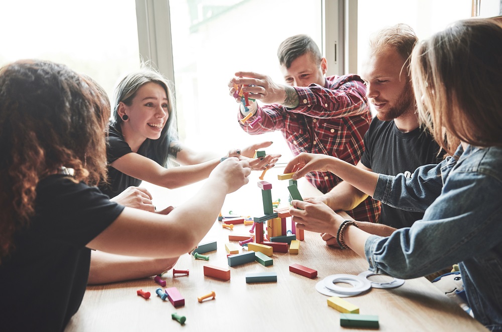 group-creative-friends-sitting-wooden-table-people-were-having-fun-while-playing-board-game.jpg