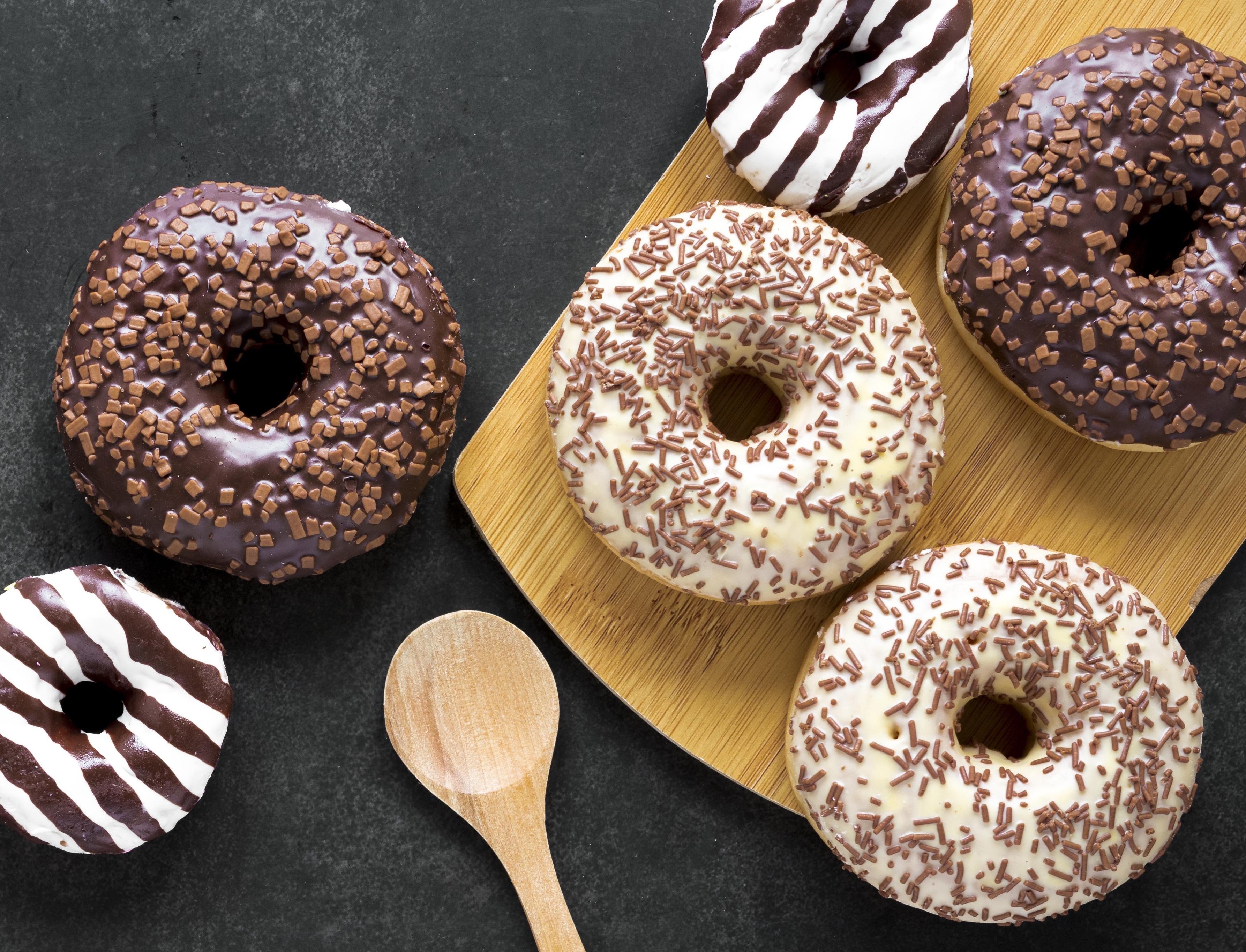 top-view-donuts-chopping-board-with-wooden-spoon.jpg