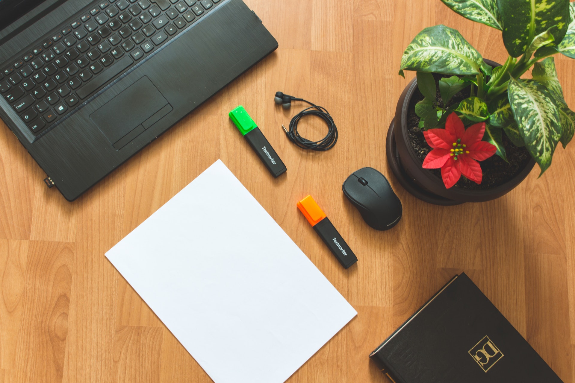 black-laptop-computer-near-white-paper-on-brown-wooden-1229476.jpg