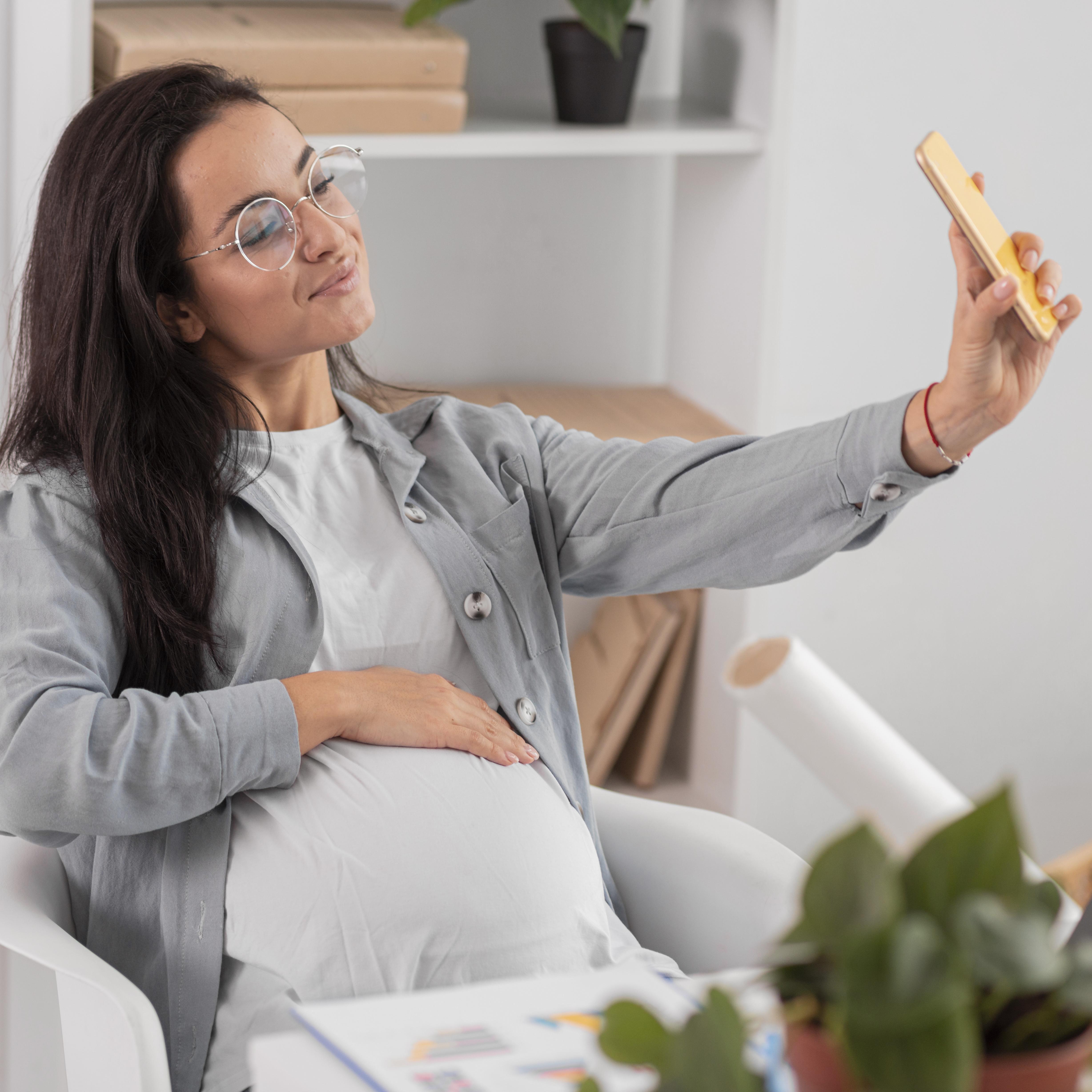 pregnant-woman-taking-selfie-home-while-working.jpg