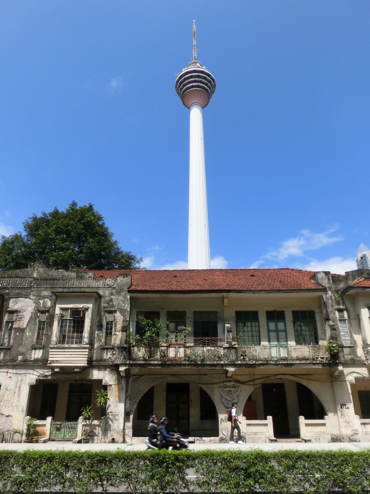 Tv-torony egy lepukkant kolonális épülettel az előtérben