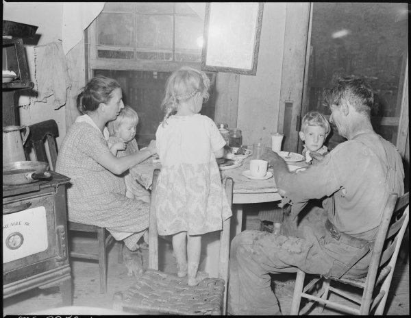 Dillard_Eldridge,_his_wife_and_children,_at_supper_in_the_four_room_house_for_which_they_pay_$9_monthly._This_is_one..._-_NARA_-_541209