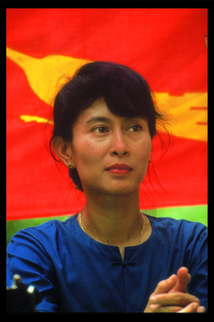 Aung-San-Suu-Kyi-in-front-of-an-NLD-Flag-682x1024.jpg
