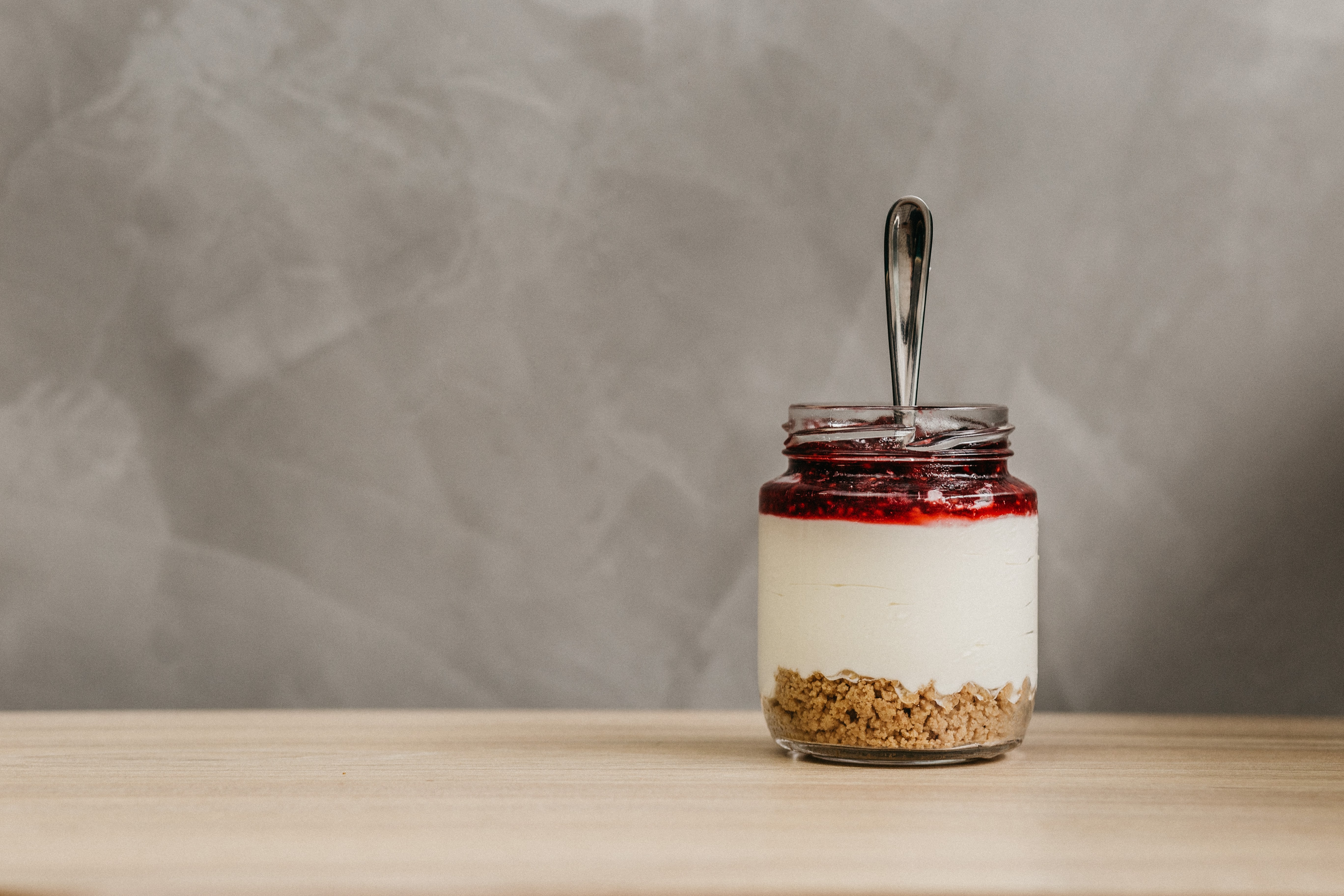 glass-jar-full-cereal-yogurt-fruit-jam-with-spoon-inside-min.jpg