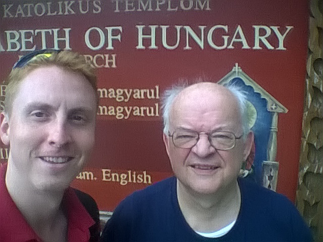 Itt Ulrich atyával feszítünk a magyar templom táblája előtt.