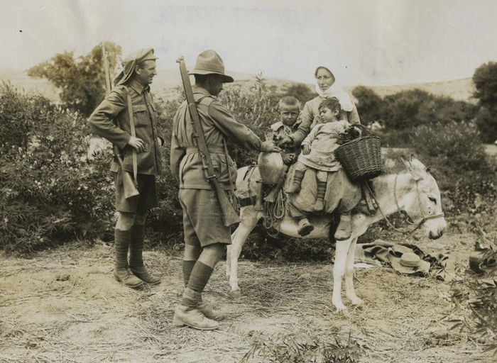 anzac_soldier_and_british_soldier_with_turkish_woman_her_children_and_donkey.jpg