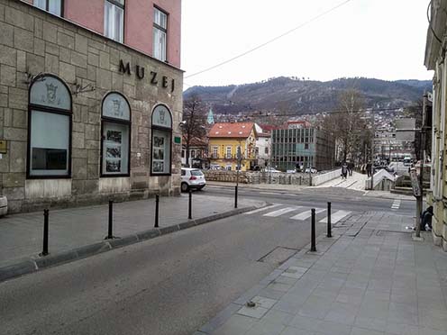 A helyszín a Miljacka folyó túloldaláról. A korabeli képeslap egy étterem falát díszíti