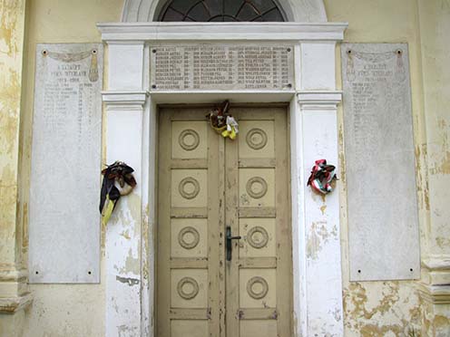 Az elesettek neveit tartalmazó fehér márvány emléktáblák a kápolna kapuja körül
