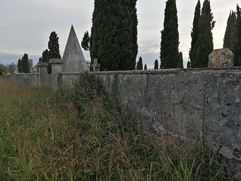 A romansi temető hátsó fala pár első világháborús sírfelirattal, a falakon belül a csontkamra is látszódik