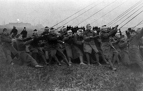 A földi személyzetként ténykedő katonák tartják a szélben a zeppelint